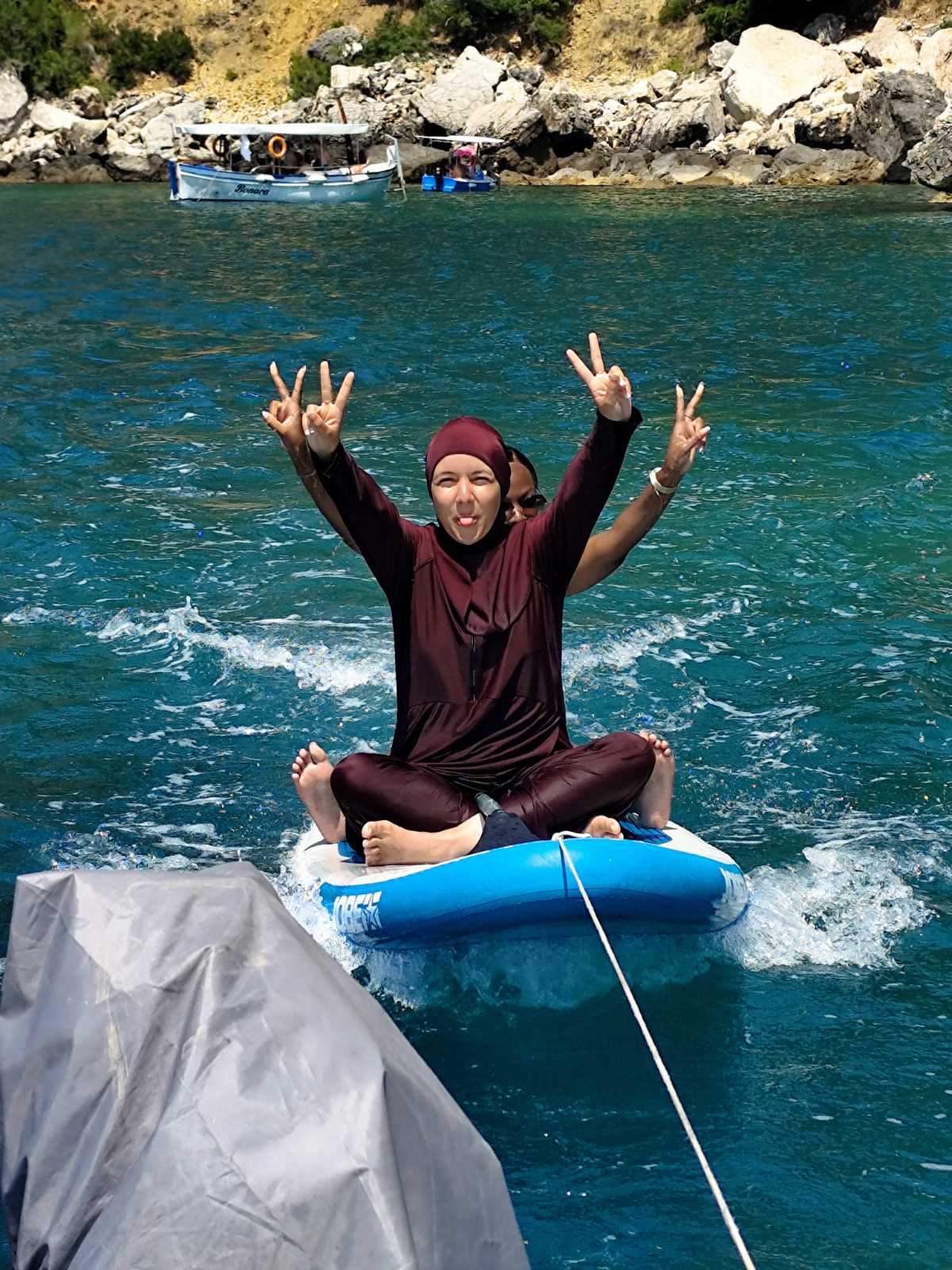 Guest smiling on a paddleboard near the coast
