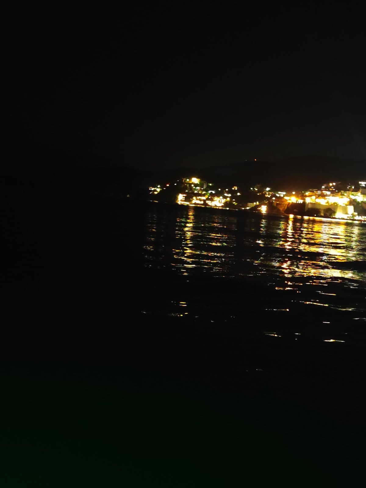 Night harbor lights seen from the water