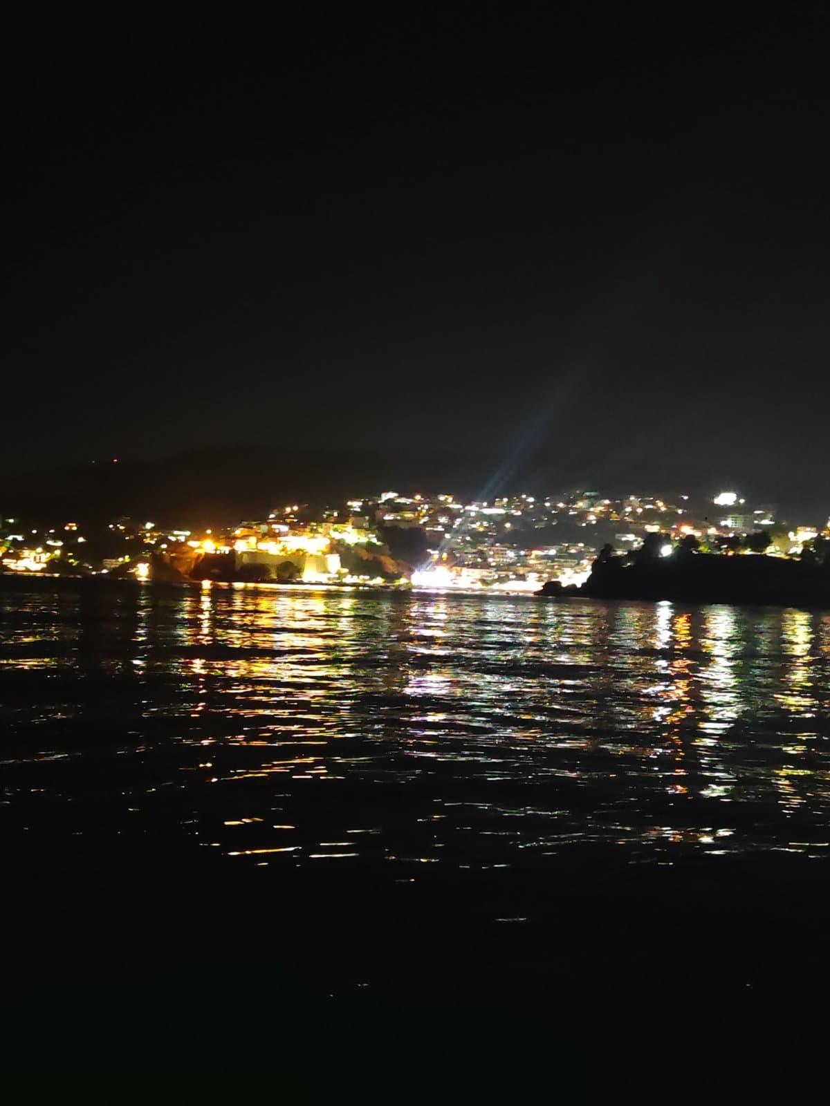 Ulqin lights reflecting across calm night water