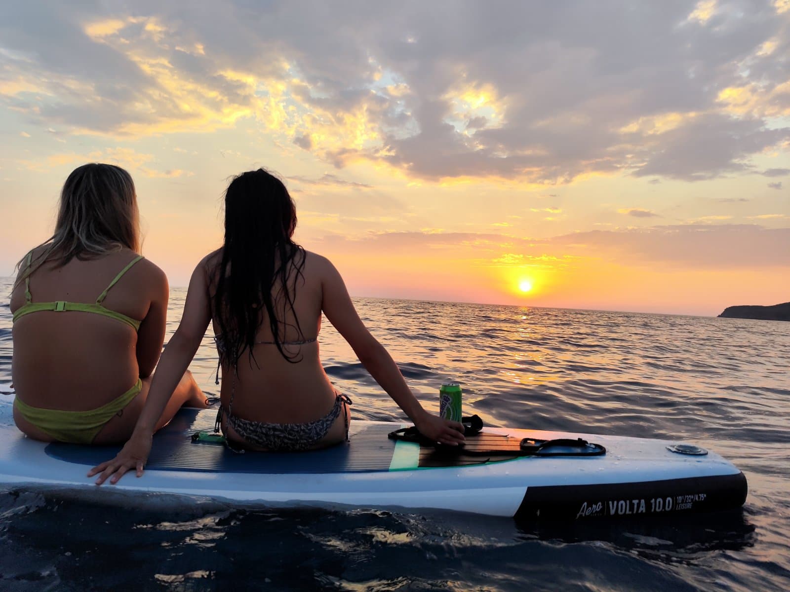 Paddleboarder watching the sunset from the water